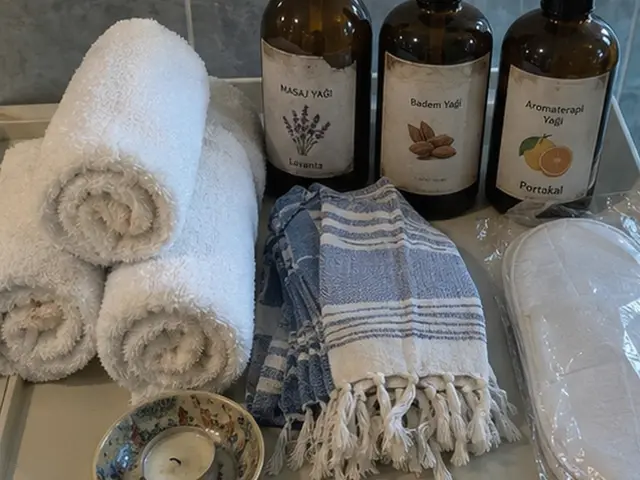 Rulo havlular, mavi peştemal ve aromaterapi yağları — Yeşilbayır, Masaj Salonun